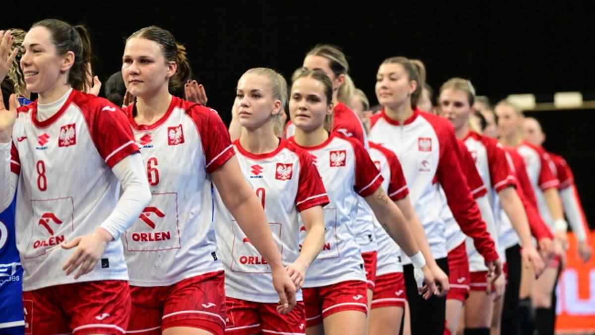 Piłkarki ręczne reprezentacji Polski w białych strojach z czerwonymi elementami, wchodzą na boisko lub prezentują się kibicom.