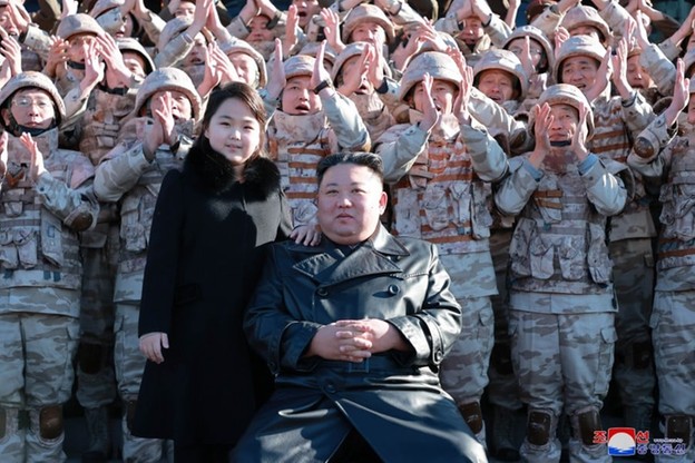 Kim Dzong Un wraz ze swoją córką na tle żołnierzy i naukowców