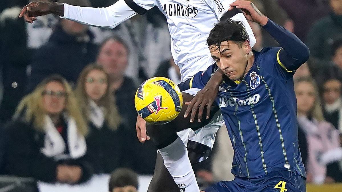 Dw&oacute;ch piłkarzy w akcji podczas meczu piłki nożnej, jeden pr&oacute;buje odebrać piłkę drugiemu.