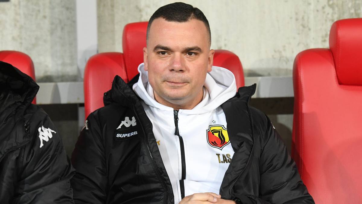 Adrian Siemieniec, trener Jagiellonii Białystok, siedzi na ławce rezerwowych.