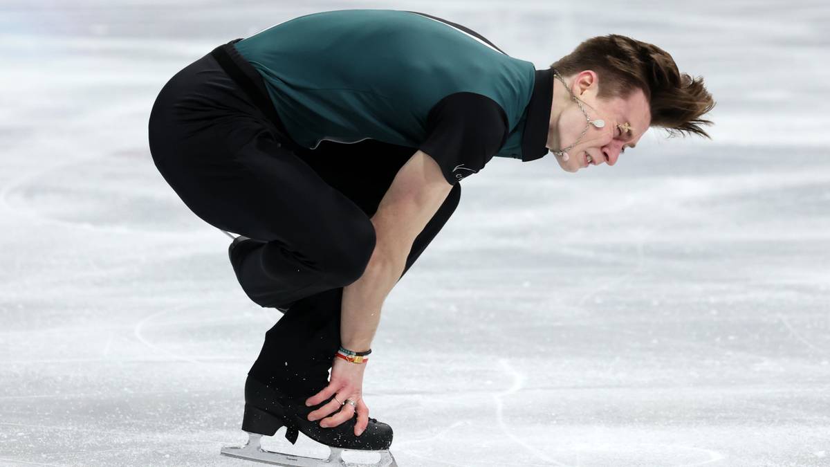 Łyżwiarz figurowy Ilia Malinin w pozycji zgiętej na lodowisku.