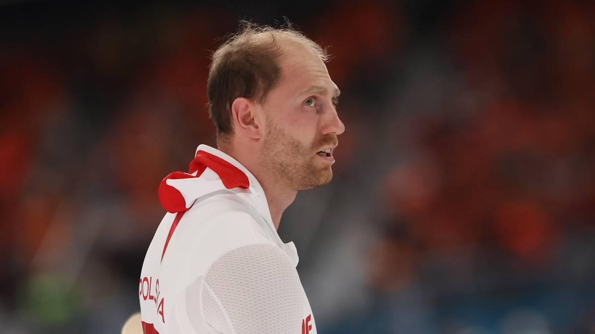 Mężczyzna w stroju sportowym, patrzący w bok.