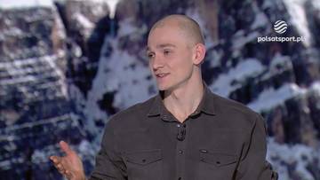 Łukasz Kuczyński w ciemnej koszuli, gestykulujący prawą ręką, z górskim tłem i logo Polsat Sport.