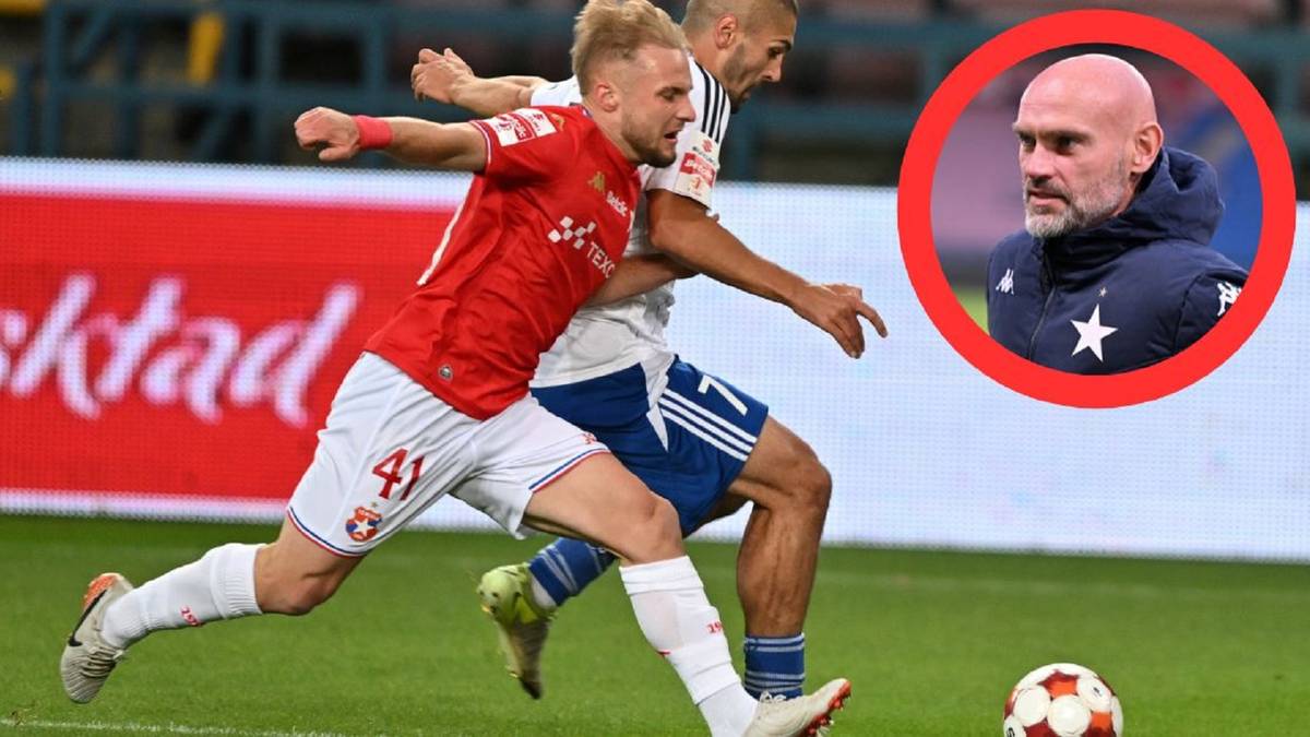 Piłkarz w czerwonej koszulce z numerem 41 na plecach biegnie z piłką, podczas gdy przeciwnik w niebieskich spodenkach próbuje go zatrzymać. W prawym górnym rogu znajduje się zdjęcie trenera w okrągłym kadrze.