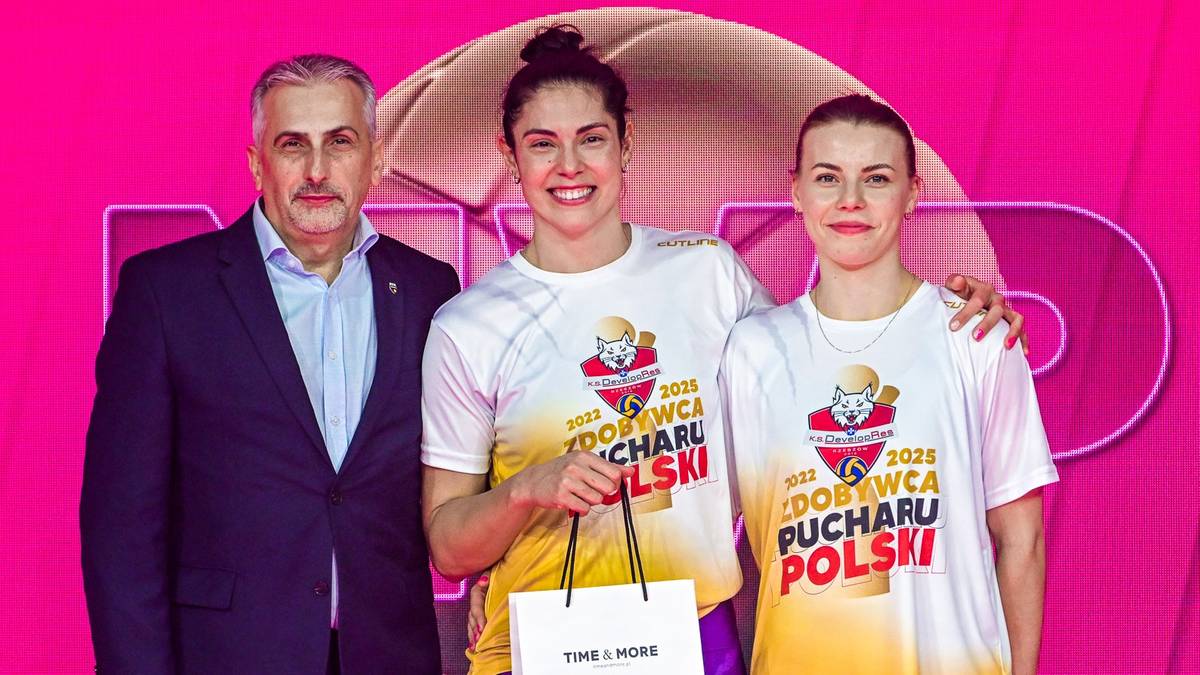 Dwóch mężczyzn i dwie kobiety stoją na tle różowego logo z napisem "Puchar Polski". Dwie kobiety w koszulkach z logiem wydarzenia trzymają w rękach torebkę. Jeden z mężczyzn jest ubrany w garnitur, a drugi w białą koszulę.