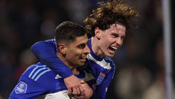 Dw&oacute;ch piłkarzy w niebiesko-białych strojach cieszy się ze zdobytej bramki. Jeden z nich obejmuje drugiego.