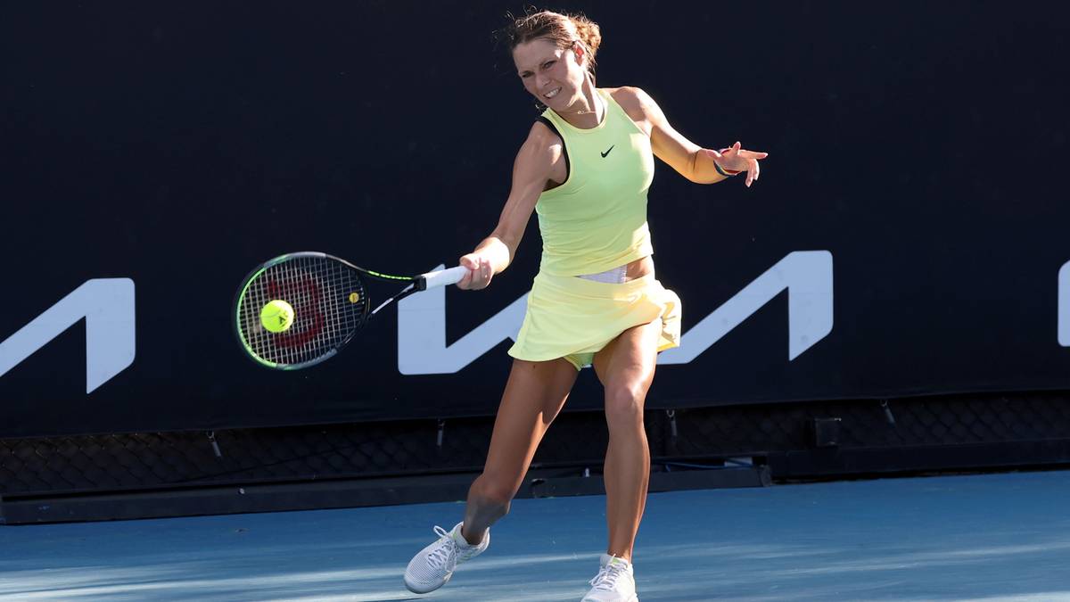 Tenisistka w żółtej sukience wykonuje forhend na korcie tenisowym.