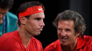 Rafael Nadal w czerwonej opasce na głowie rozmawia z Francisco Roigiem.
