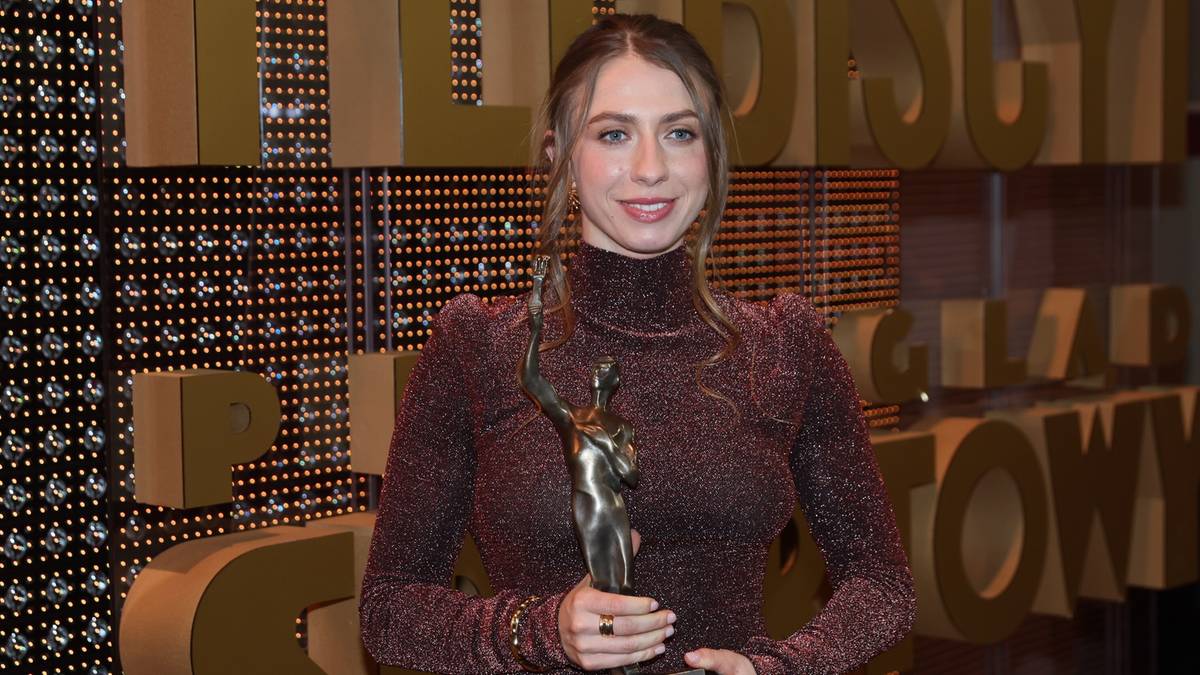 Kobieta trzymająca statuetkę.