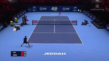 Dw&oacute;ch tenisist&oacute;w, Learner Tien i Rafael Jodar, grają mecz na niebieskim korcie tenisowym. Na ekranie widoczny jest wynik meczu.