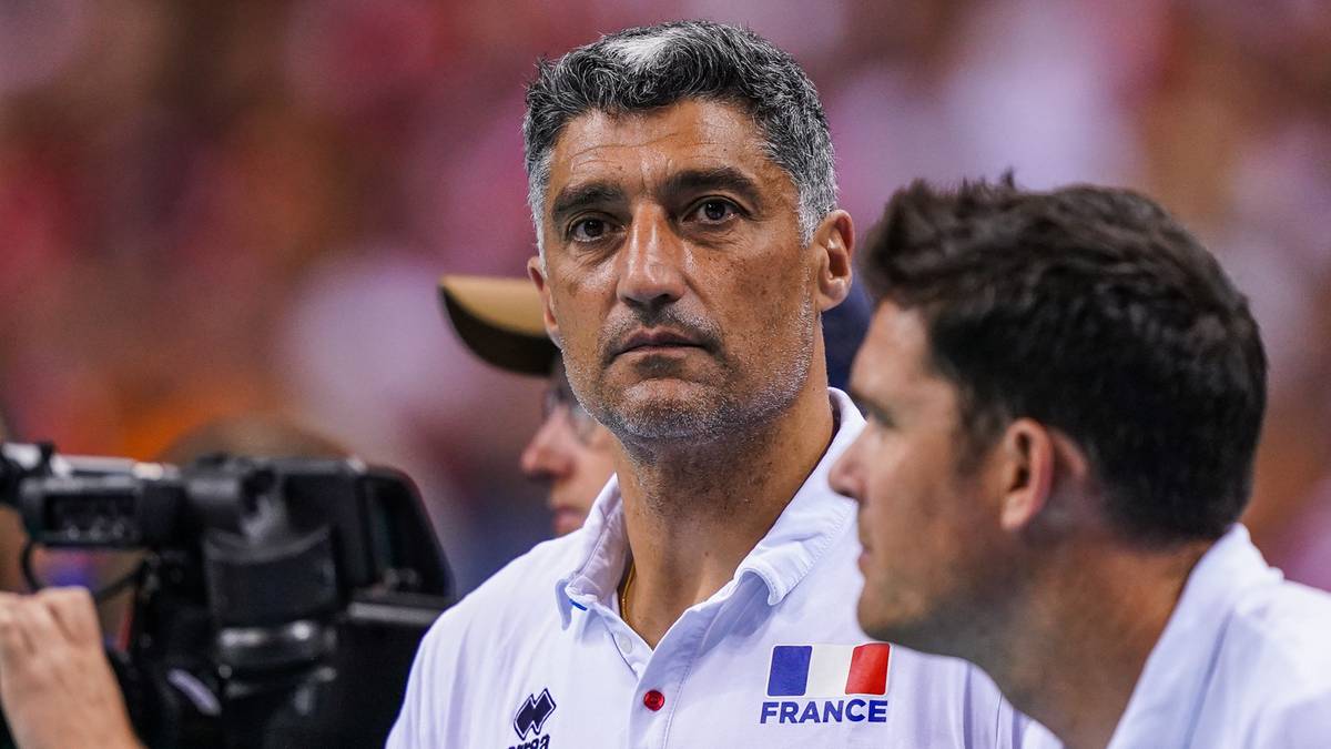 Trener siatk&oacute;wki w białej koszulce z logo Francji.