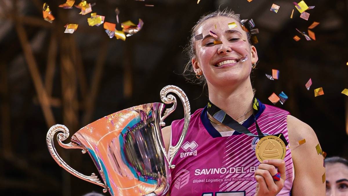 Uśmiechnięta siatkarka Ekaterina Antropova trzyma w rękach puchar i złoty medal.