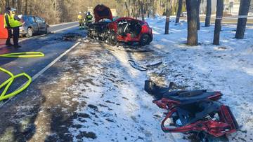 Miejsce wypadku drogowego z udziałem dw&oacute;ch samochod&oacute;w osobowych, w&oacute;z strażacki i służby ratownicze na drodze.