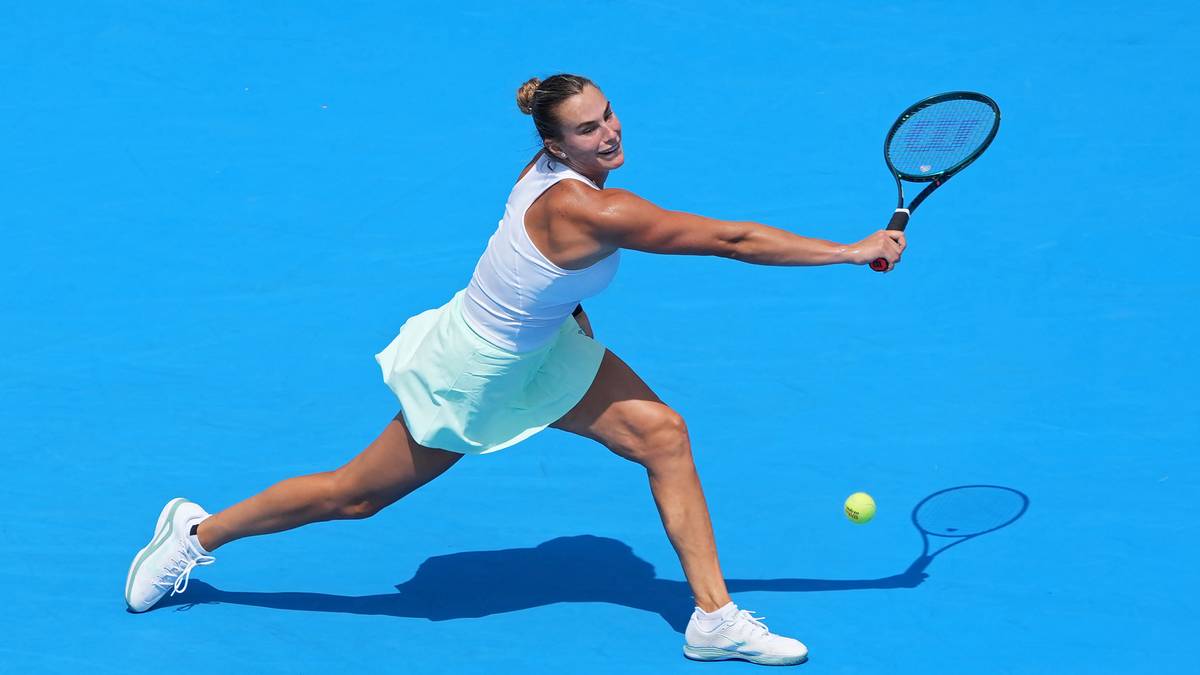 Agnieszka Radwańska z rakietą tenisową w akcji na korcie tenisowym z niebieską nawierzchnią.