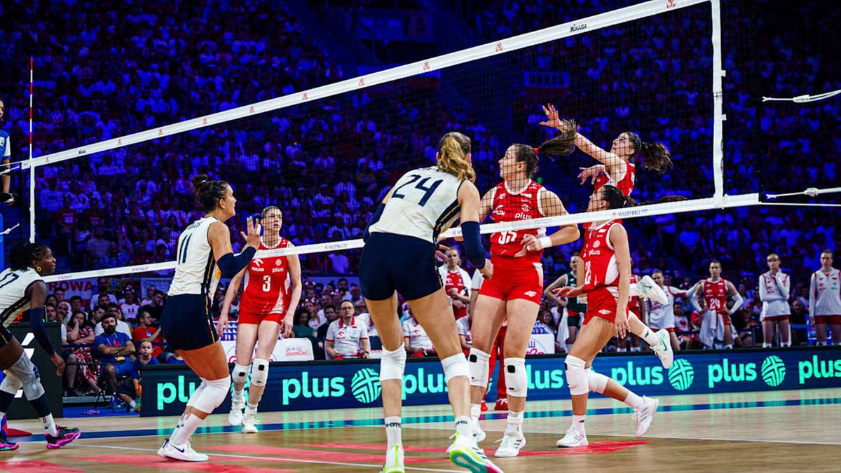 Siatkarki podczas meczu, jedna zawodniczka wykonuje atak, pozostałe reagują.