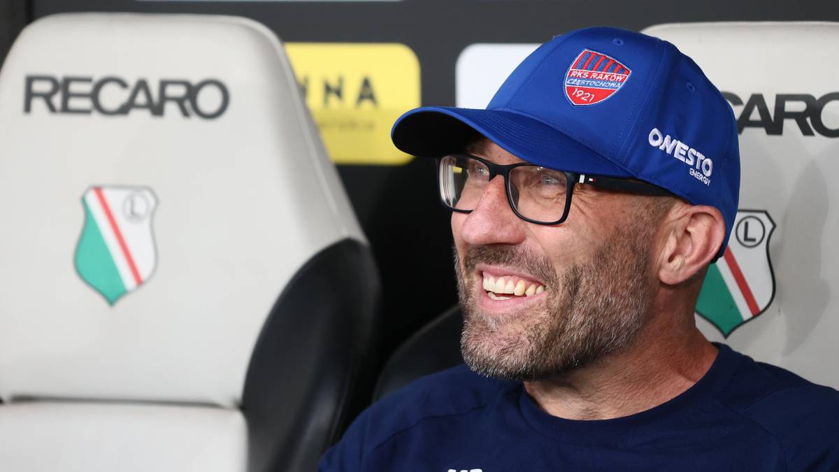 Mężczyzna w niebieskiej czapce i okularach uśmiecha się, siedząc na ławce.