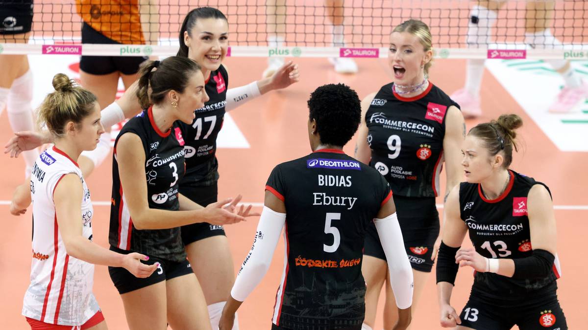 Grupa kobiet w strojach siatkarskich na boisku, niektóre patrzą na siebie z emocjami.