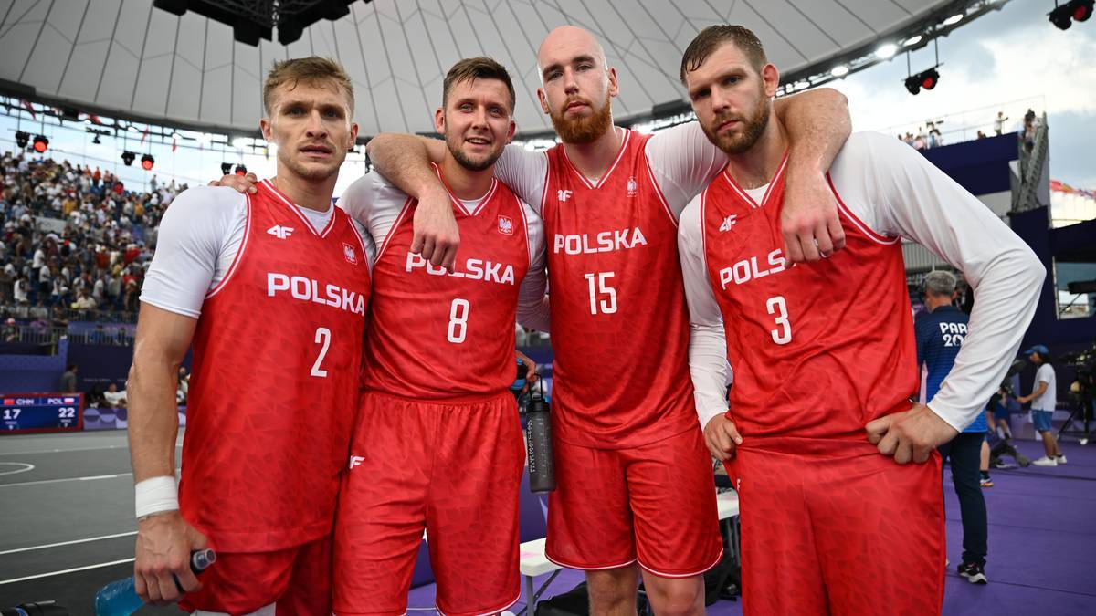 Czterech mężczyzn w koszulkach z napisem POLSKA i numerami na plecach, pozujących do zdjęcia.