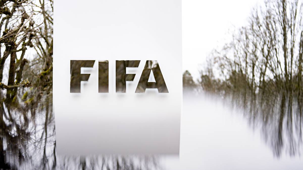 Logotyp FIFA na białym tle, z elementami zimowego krajobrazu po bokach.