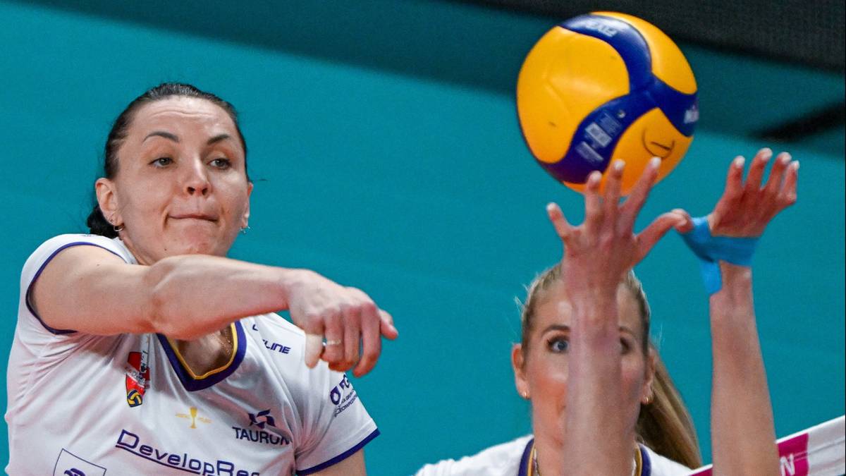 Dwie siatkarki walczą o piłkę przy siatce, jedna blokuje atak.