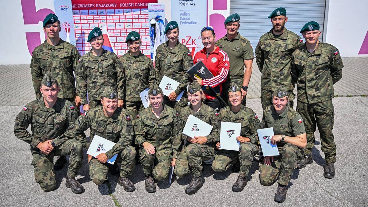 Grupa polskich kajakarzy i kanadyjkarzy w mundurach wojskowych z medalami i dyplomami po zawodach.