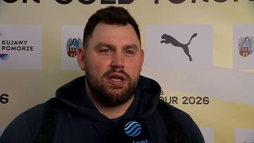 Konrad Bukowiecki, polski lekkoatleta, podczas wywiadu. Ma na sobie ciemną bluzę z kapturem. W tle widoczne są logotypy sponsor&oacute;w, w tym PUMA.