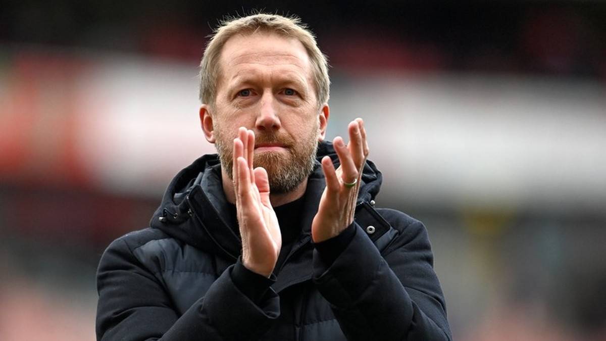 Mężczyzna o jasnej karnacji i kr&oacute;tkich blond włosach, z lekko przypr&oacute;szonym zarostem, klaska w dłonie. Jest ubrany w ciemną kurtkę z wysokim kołnierzem. Tło jest rozmyte, z elementami trybun.