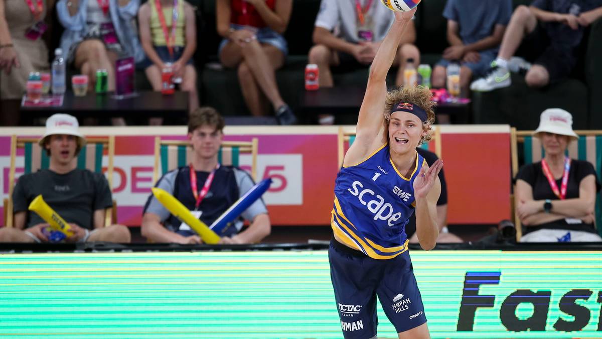 Siatkarz plażowy serwujący piłkę w trakcie meczu.