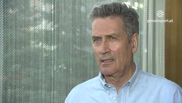 Portret starszego mężczyzny o siwych włosach, z widocznymi zmarszczkami na twarzy. Jego wyraz twarzy jest przygnębiony, sugeruje niezadowolenie lub frustrację. W tle znajduje się jasna, rozmyta siatka i fragment logo Polsat Sport.