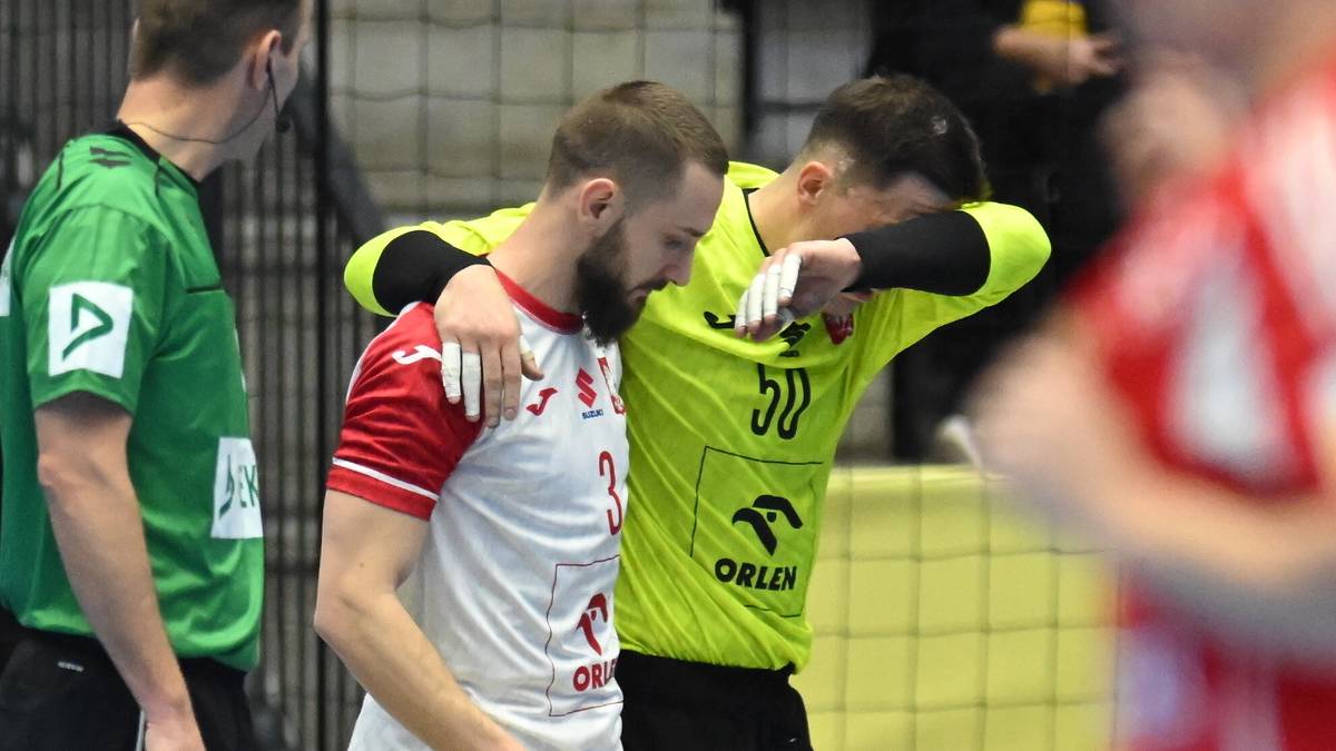 Piłkarz ręczny w białej koszulce z czerwonymi rękawami, wspierany przez kolegę z drużyny w jaskrawoż&oacute;łtej koszulce.