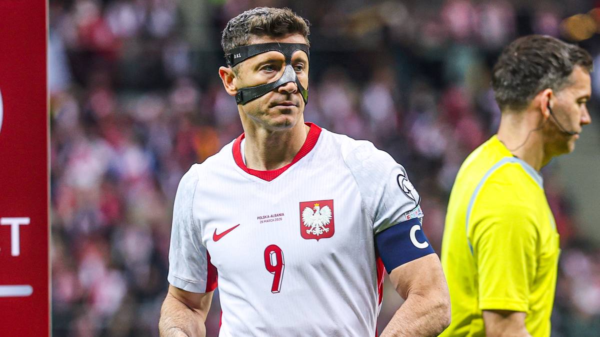 Piłkarz reprezentacji Polski w białej koszulce trzyma biało-czerwoną flagę obok czerwonego banera z napisem RESPECT i logo UEFA.