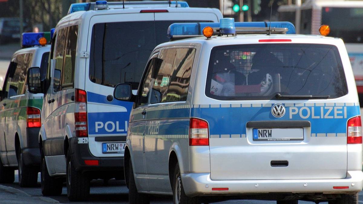 Kilka radiowozów niemieckiej policji z włączonymi sygnałami świetlnymi.