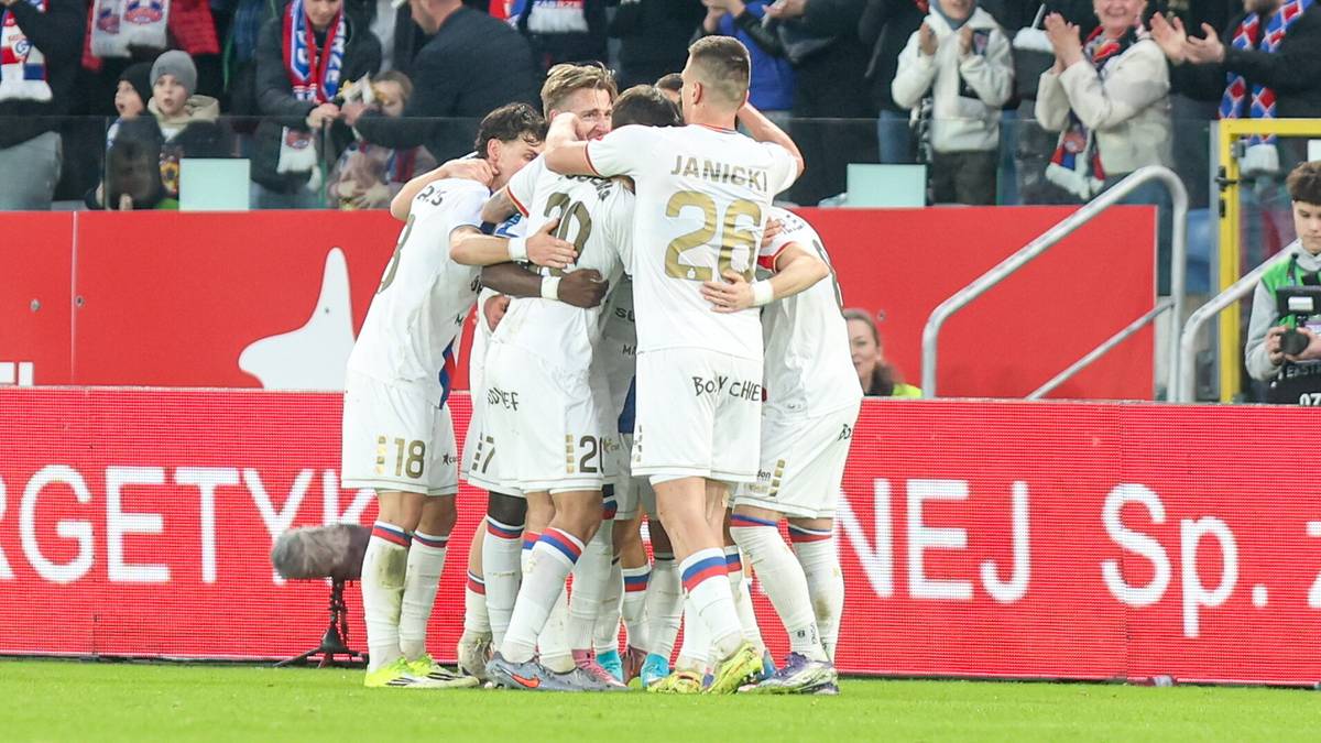 Piłkarze G&oacute;rnika Zabrze świętują zdobycie bramki, przytulając się do siebie na murawie stadionu.