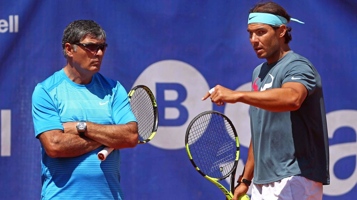 Trener Toni Nadal rozmawia z zawodnikiem tenisa Rafaelem Nadalem na korcie.