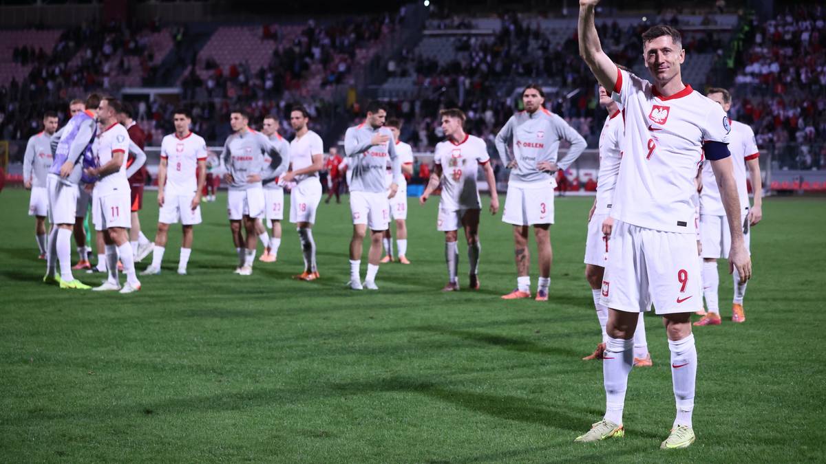 Robert Lewandowski w koszulce reprezentacji Polski macha do kibiców.