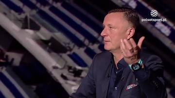 Tomasz Hajto w garniturze, gestykuluje prawą ręką, przemawiając podczas wywiadu w studiu telewizyjnym.