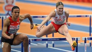 Dwie lekkoatletki biegnące przez płotki na bieżni.