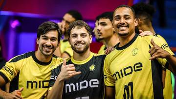 Czterech młodych mężczyzn w ż&oacute;łtych koszulkach sportowych z napisami "MIDE" i numerami na plecach, uśmiechających się do kamery.