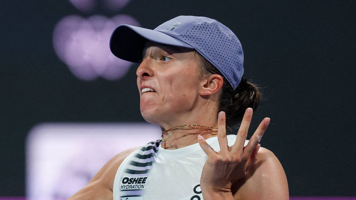 Tenisistka w akcji podczas meczu, uderzająca piłkę rakietą.