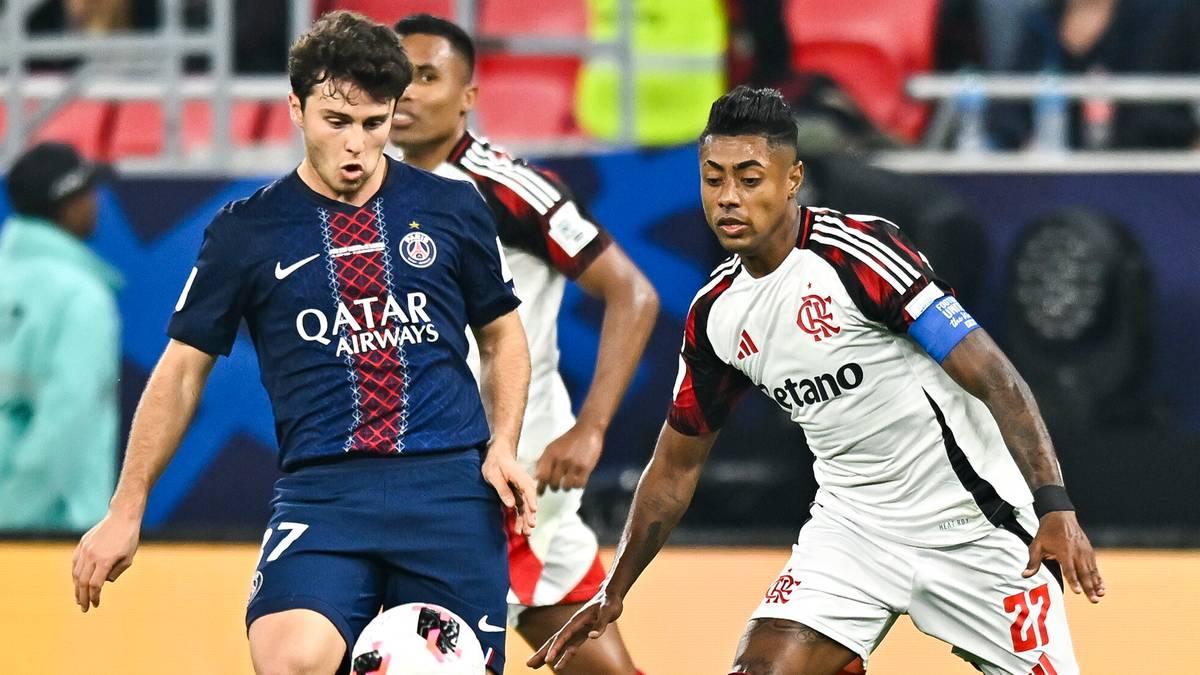 Dw&oacute;ch piłkarzy w akcji na boisku piłkarskim, jeden w granatowej koszulce PSG z napisem Qatar, drugi w białej koszulce Flamengo.