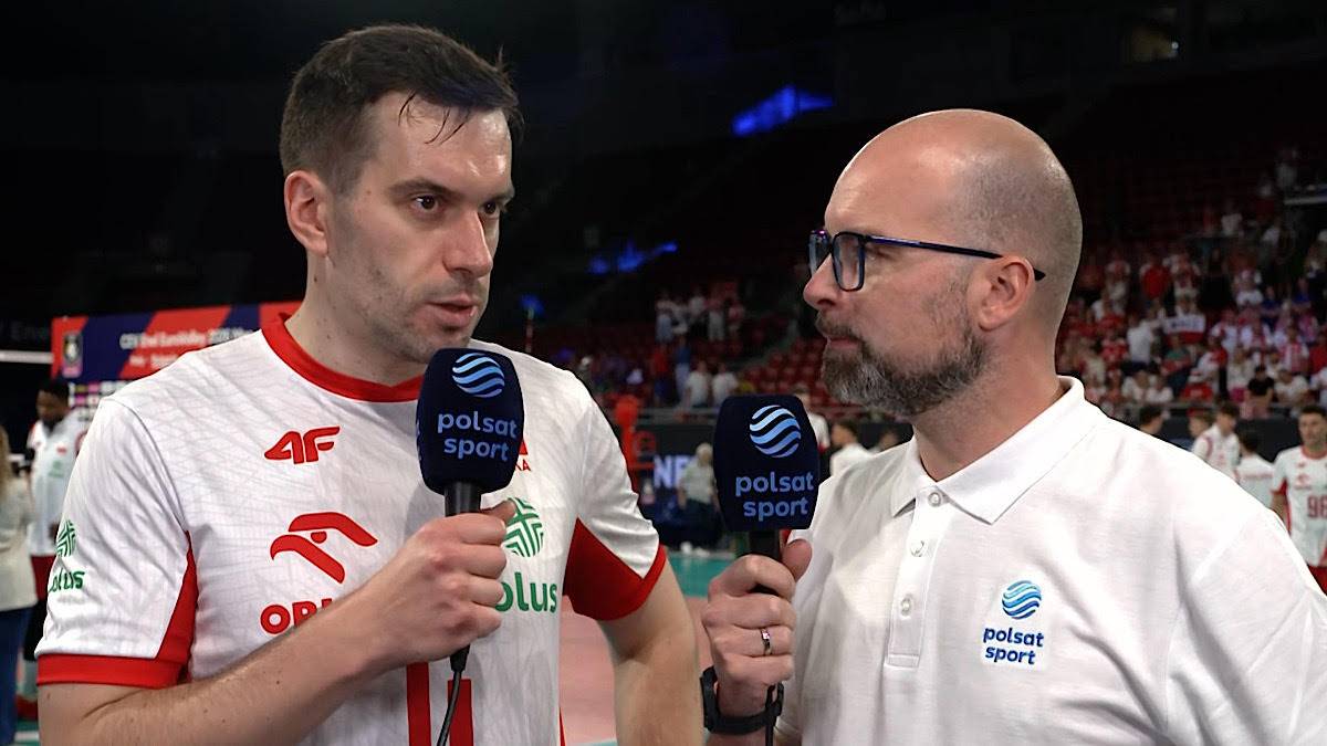 Dwóch mężczyzn rozmawia z mikrofonami Polsat Sport. Jeden z nich jest sportowcem w stroju z biało-czerwonymi elementami, drugi ma okulary i białą koszulkę.