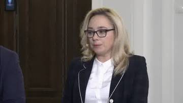 Kobieta w okularach i formalnym stroju.