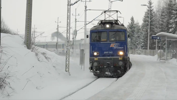 Niebieska lokomotywa PKP Intercity EP07-342 jedzie po oblodzonych torach w zaśnieżonym krajobrazie.
