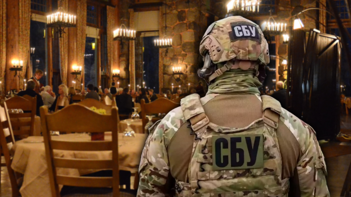 Żołnierz Służby Bezpieczeństwa Ukrainy (СБУ) w mundurze stoi w tle restauracji z zastawionymi stołami.