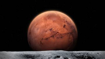 Czerwona planeta Merkury na tle czarnego kosmosu, widoczna nad szarym, skalistym krajobrazem.