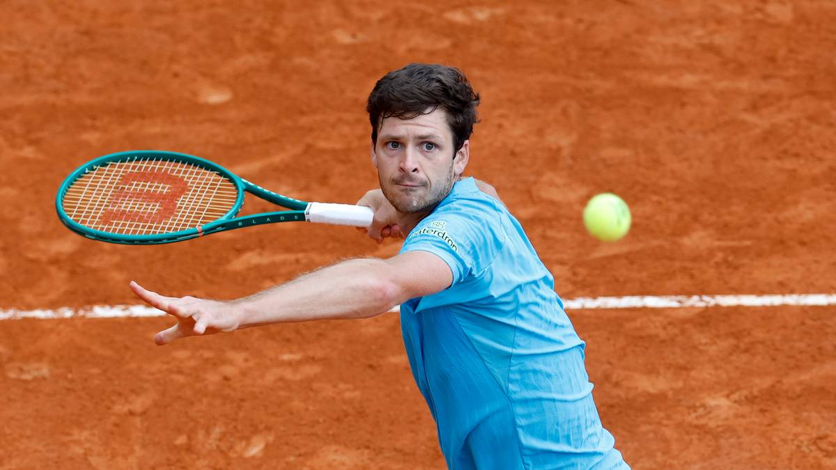 Tenisista Hubert Hurkacz uderza piłkę forhendem na ceglanym korcie tenisowym.