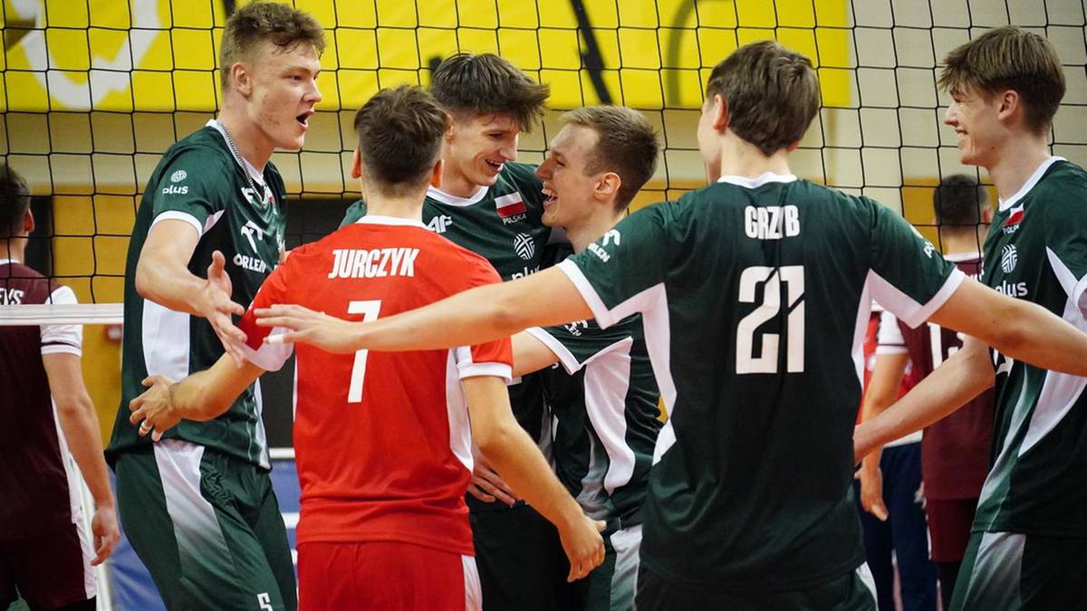 Grupa młodych siatkarzy w zielonych i czerwonych strojach cieszy się z wygranej po meczu.