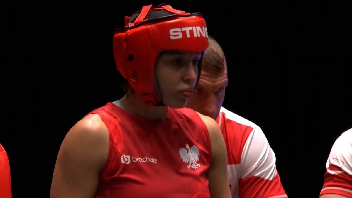 Portret kobiety bokserki w czerwonym kasku i stroju sportowym z godłem Polski.