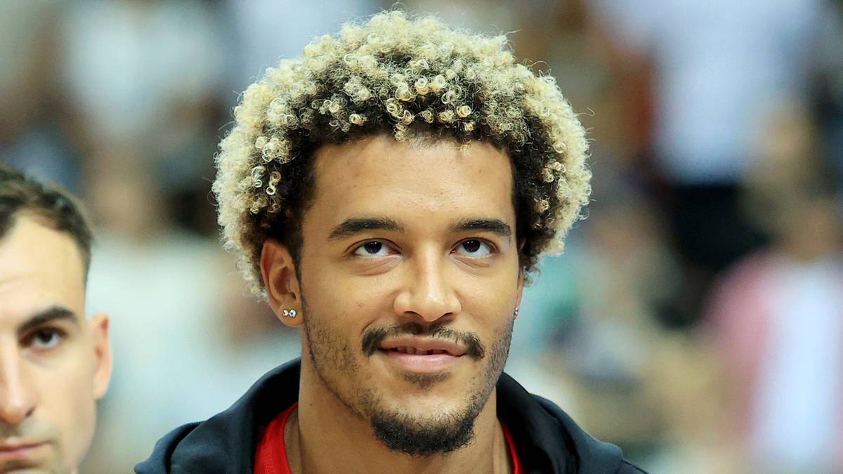 Jeremy Sochan w bluzie z polską flagą, z innymi zawodnikami w tle.