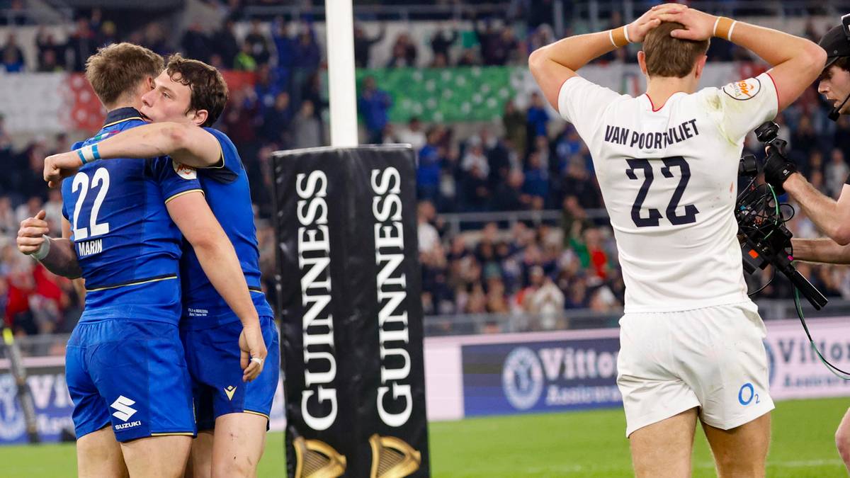 Trzech włoskich rugbyst&oacute;w przytula się po zwycięskim meczu, jeden z nich ma na plecach numer 22. W tle widać angielskiego zawodnika z numerem 22 na plecach, stojącego z rękami na głowie, oraz kibic&oacute;w na trybunach.